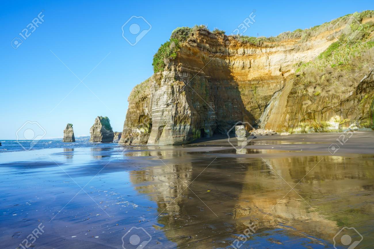 blue water golden rocks and sand on the beach 3 sisters and