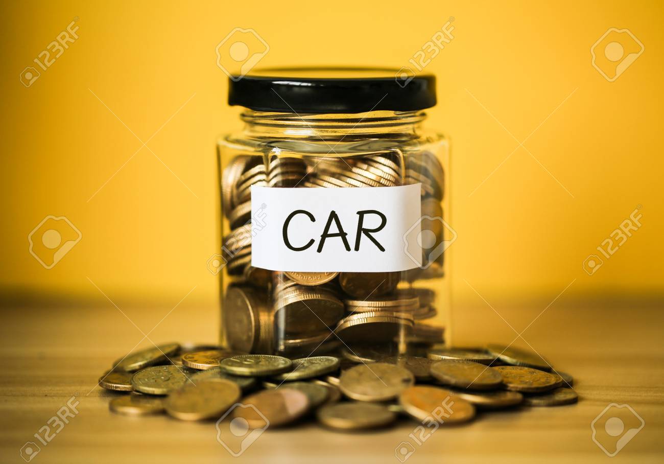 A lot coins in glass money jar with yellow background. Saving for car concept. - 98012334 A lot coins in glass money jar with yellow background. Saving for car concept. - 98012334