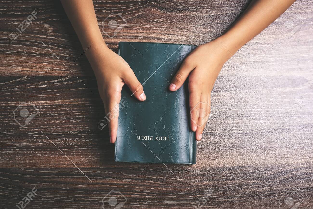 Hands with holy bible on the wooden desk. - 124032431 Hands with holy bible on the wooden desk. - 124032431