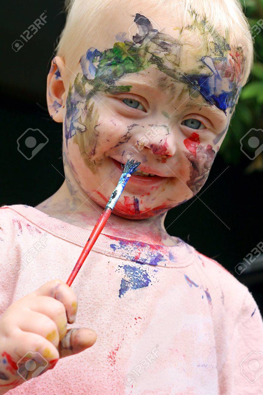 ペイント ブラシで彼自身の顔の虹色以上すべての笑みを浮かべて かわいい赤ちゃんが絵します の写真素材 画像素材 Image