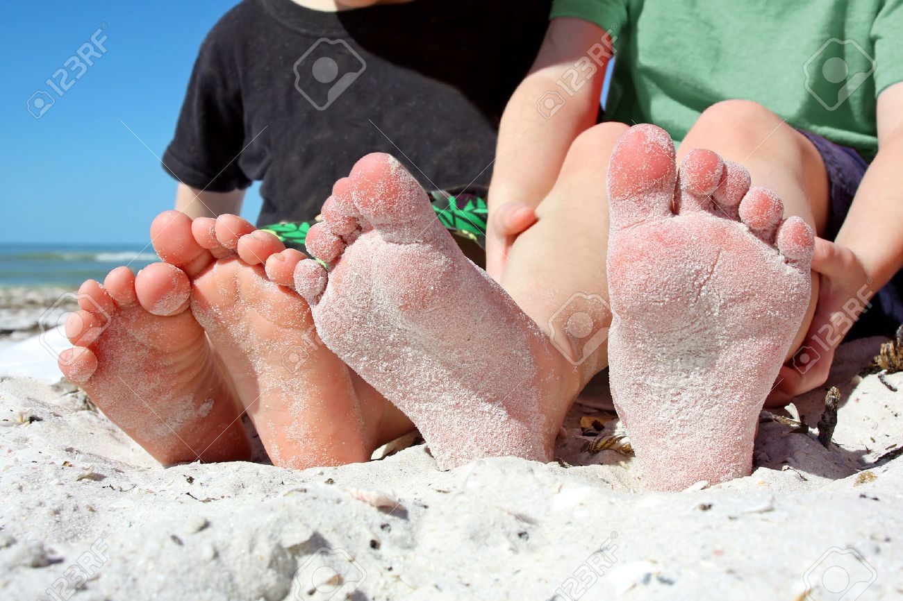 two young children's feet are seen, covered in sand as they sit on the beach by the ocean - 25597669 two young children's feet are seen, covered in sand as they sit on the beach by the ocean - 25597669
