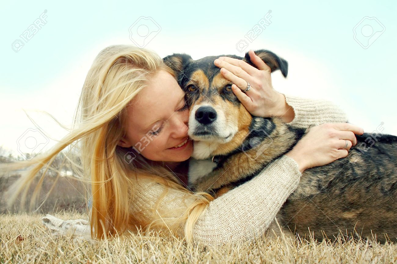 a young caucasian woman is laying outside with her German Shepherd Dog, hugging him lovingly - 27613758 a young caucasian woman is laying outside with her German Shepherd Dog, hugging him lovingly - 27613758