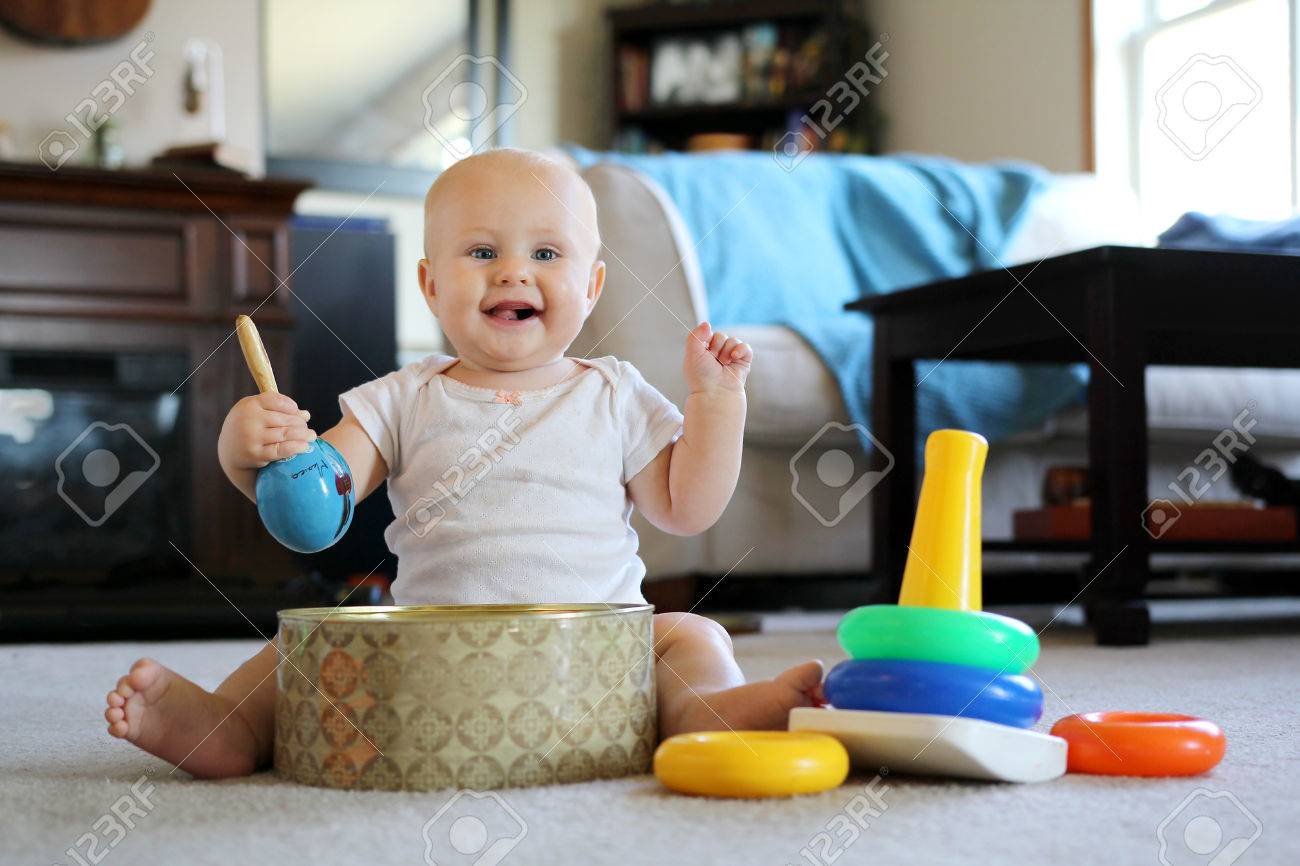 Un 8 Meses Sonriente Bebe Feliz De Edad Se Teclea Con Maracas Y Jugando Con Los Juguetes De Aprendizaje De Apilamiento Rosquilla En Su Casa Fotos Retratos Imagenes Y Fotografia De Archivo