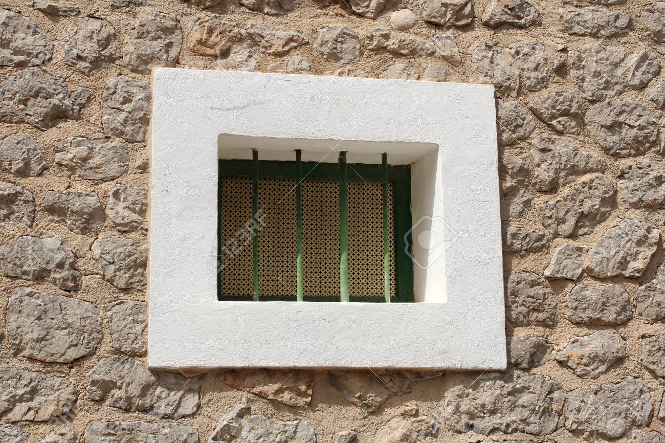 Pequena Ventana Con Las Barras En La Pared De Piedra Fotos