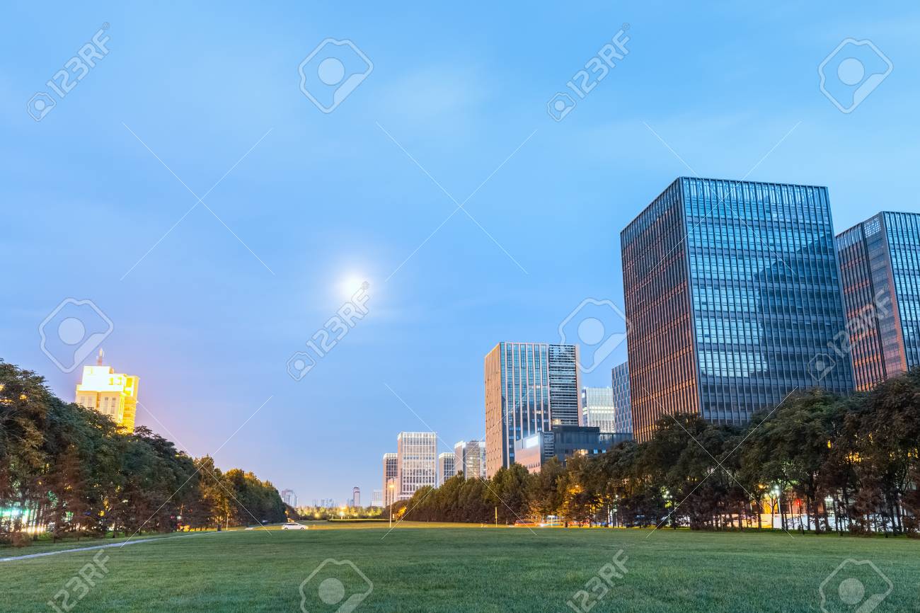 modern buildings with green space in nightfall binhai new district