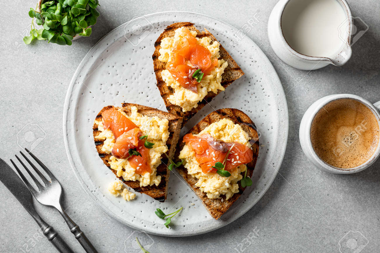 scrambled eggs toast with salmon and microgreens on a white ceramic plate, selective focus, view from above - 169788390 scrambled eggs toast with salmon and microgreens on a white ceramic plate, selective focus, view from above - 169788390