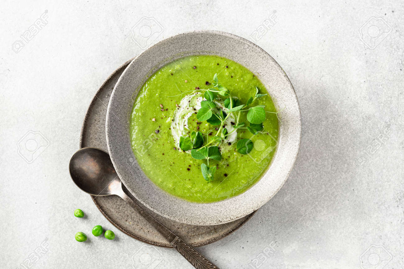 Green pea soup in a ceramic bowl on gray concrete background, top view - 169788417 Green pea soup in a ceramic bowl on gray concrete background, top view - 169788417