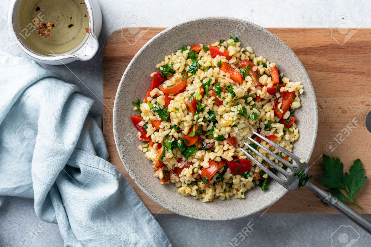Traditional oriental salad Tabouleh with bulgur and parsley on concrete background, view from above - 169788428 Traditional oriental salad Tabouleh with bulgur and parsley on concrete background, view from above - 169788428