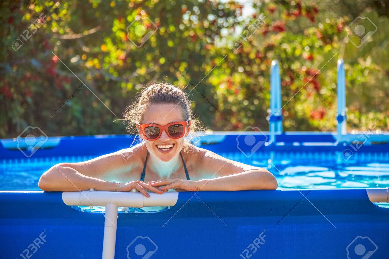 Fun weekend alfresco. Portrait of happy healthy woman in blue beachwear in the swimming pool in sunglasses - 75524549 Fun weekend alfresco. Portrait of happy healthy woman in blue beachwear in the swimming pool in sunglasses - 75524549