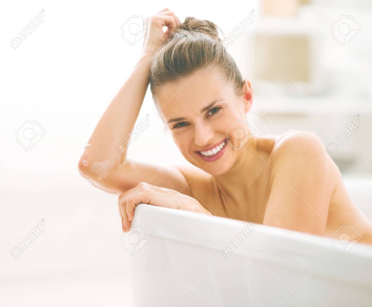 Portrait of smiling young woman in bathtub - 80681552 Portrait of smiling young woman in bathtub - 80681552