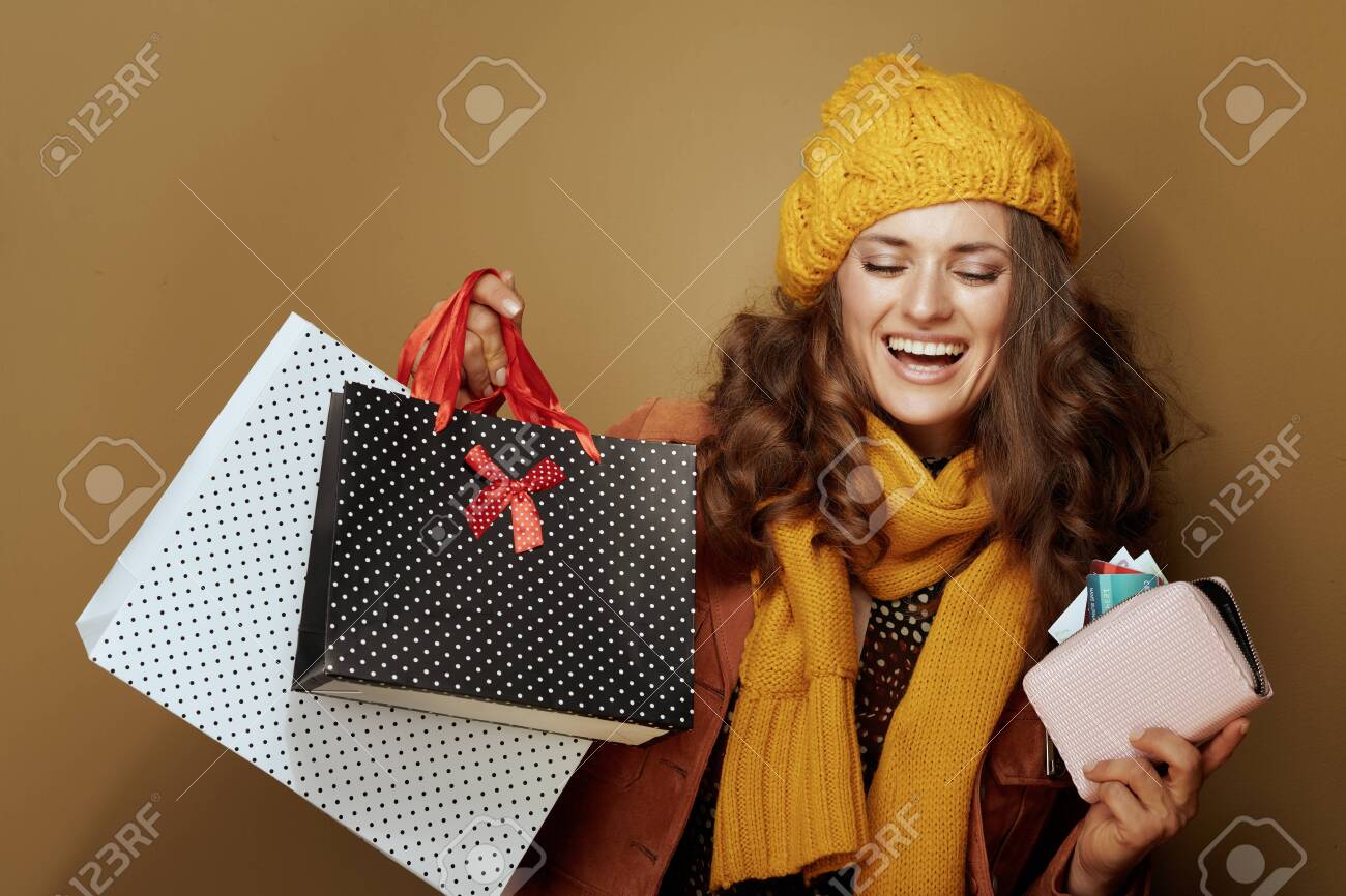Hello autumn. happy young woman in yellow beret and scarf with credit card, purse and shopping bags isolated on beige. - 129565975 Hello autumn. happy young woman in yellow beret and scarf with credit card, purse and shopping bags isolated on beige. - 129565975