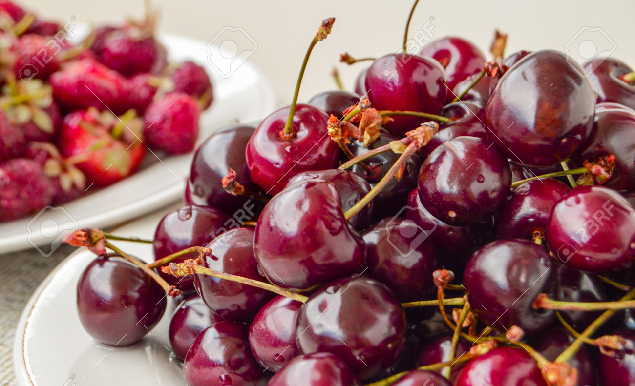 Lots of ripe juicy cherries in a white bowl, summer berry harvest, food background - 169661571 Lots of ripe juicy cherries in a white bowl, summer berry harvest, food background - 169661571