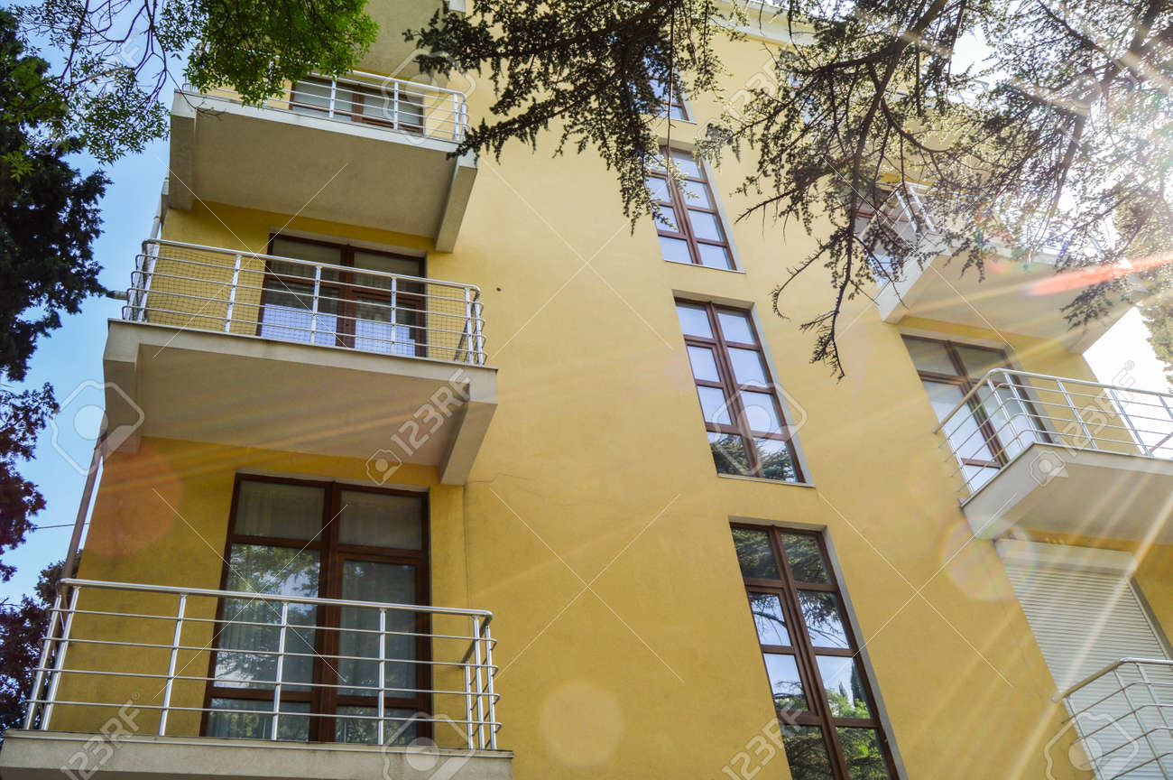 Modern beautiful luxury yellow resort building with balconies, Sunny summer day - 169661596 Modern beautiful luxury yellow resort building with balconies, Sunny summer day - 169661596