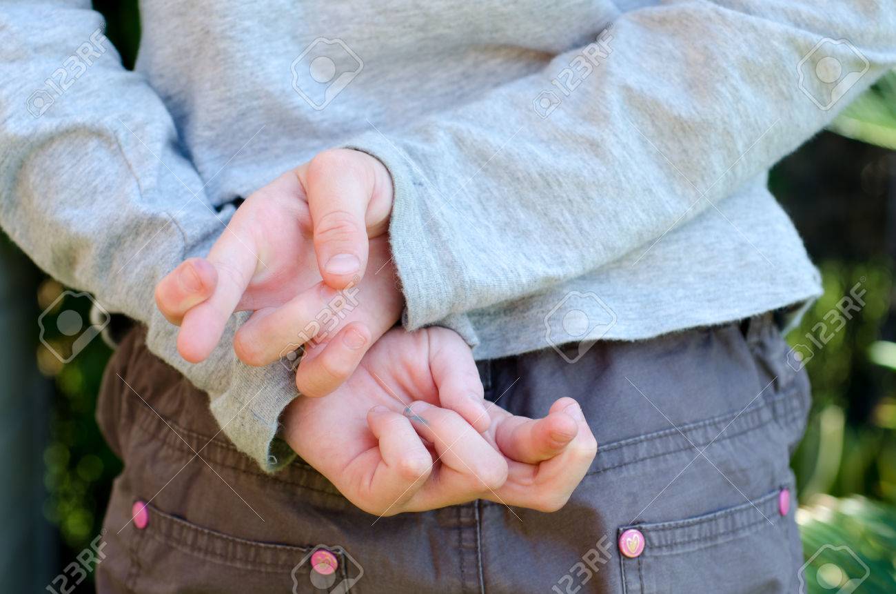 Enfant Avec Les Doigts Croisés Derrière Le Dos Banque D'Images Et Photos  Libres De Droits. Image 60821399.