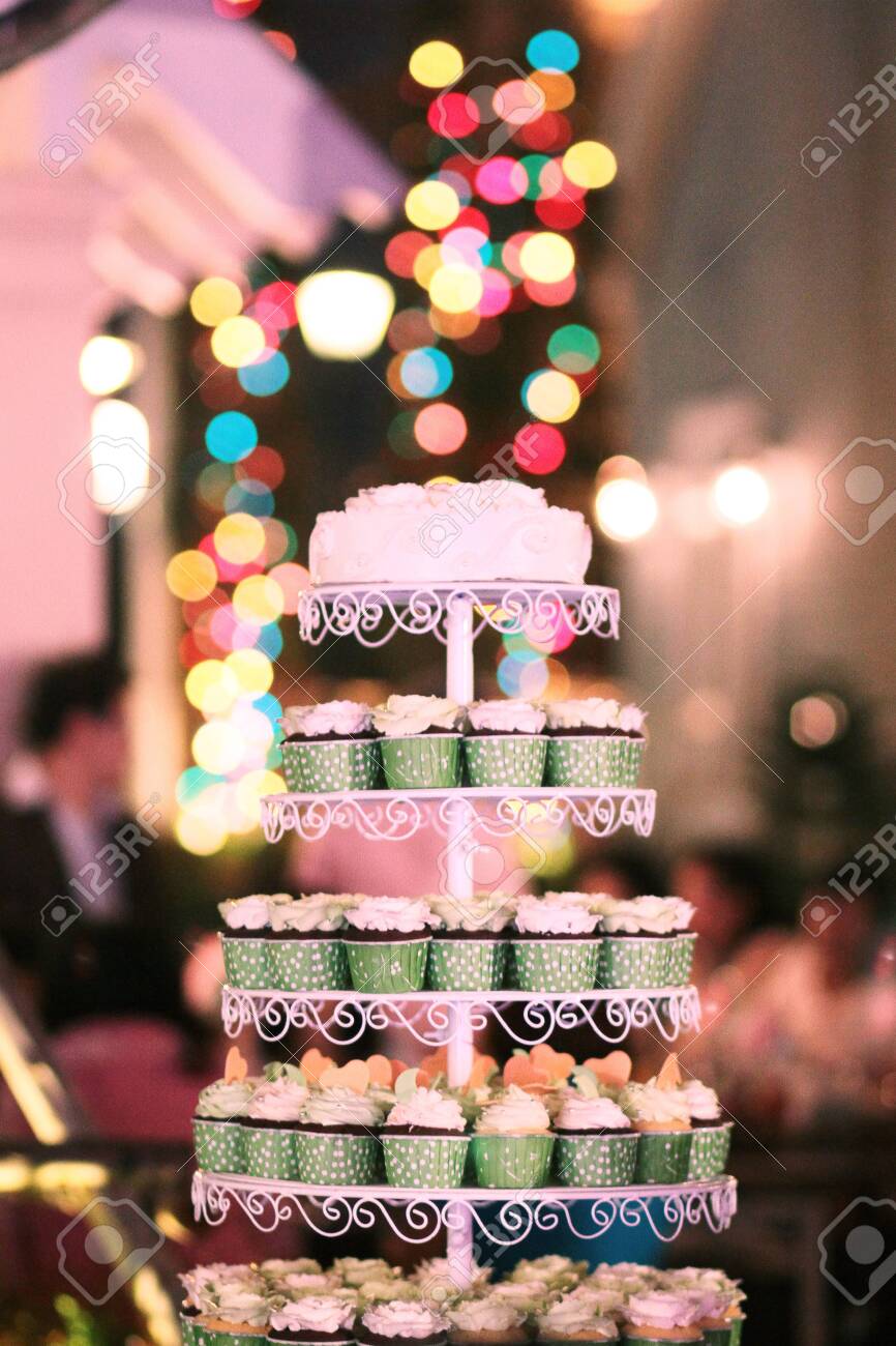 Wedding Cupcakes with colorful sprinkles in green cup with garland lights bokeh background - 149943625 Wedding Cupcakes with colorful sprinkles in green cup with garland lights bokeh background - 149943625