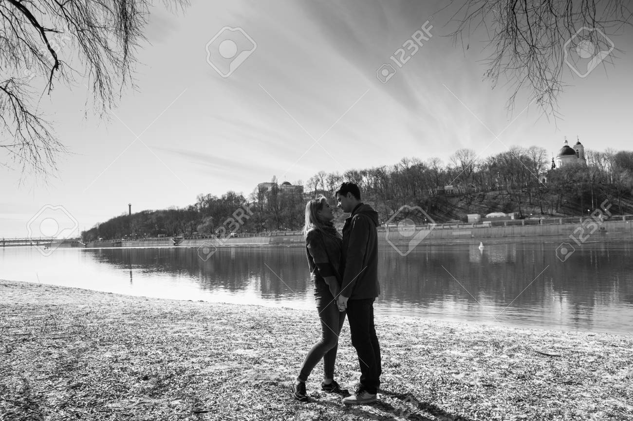 陽気なラブラブ カップルのキスします 川の土手と抱擁の上を歩く の写真素材 画像素材 Image