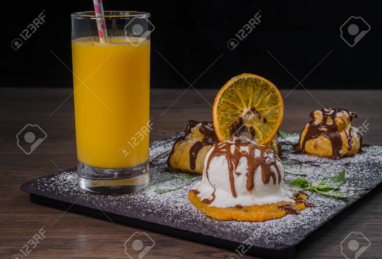 a ball of ice cream on a stone background with an orange glass