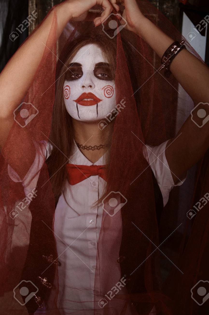 Halloween, Le Mysticisme, La Magie, Le Mystère. Maquillage Dans Le Style De  Billy Poupée. Danse De Sorcière Dans Une Cape Rouge Banque D'images Et  Photos Libres De Droits. Image 47860249.