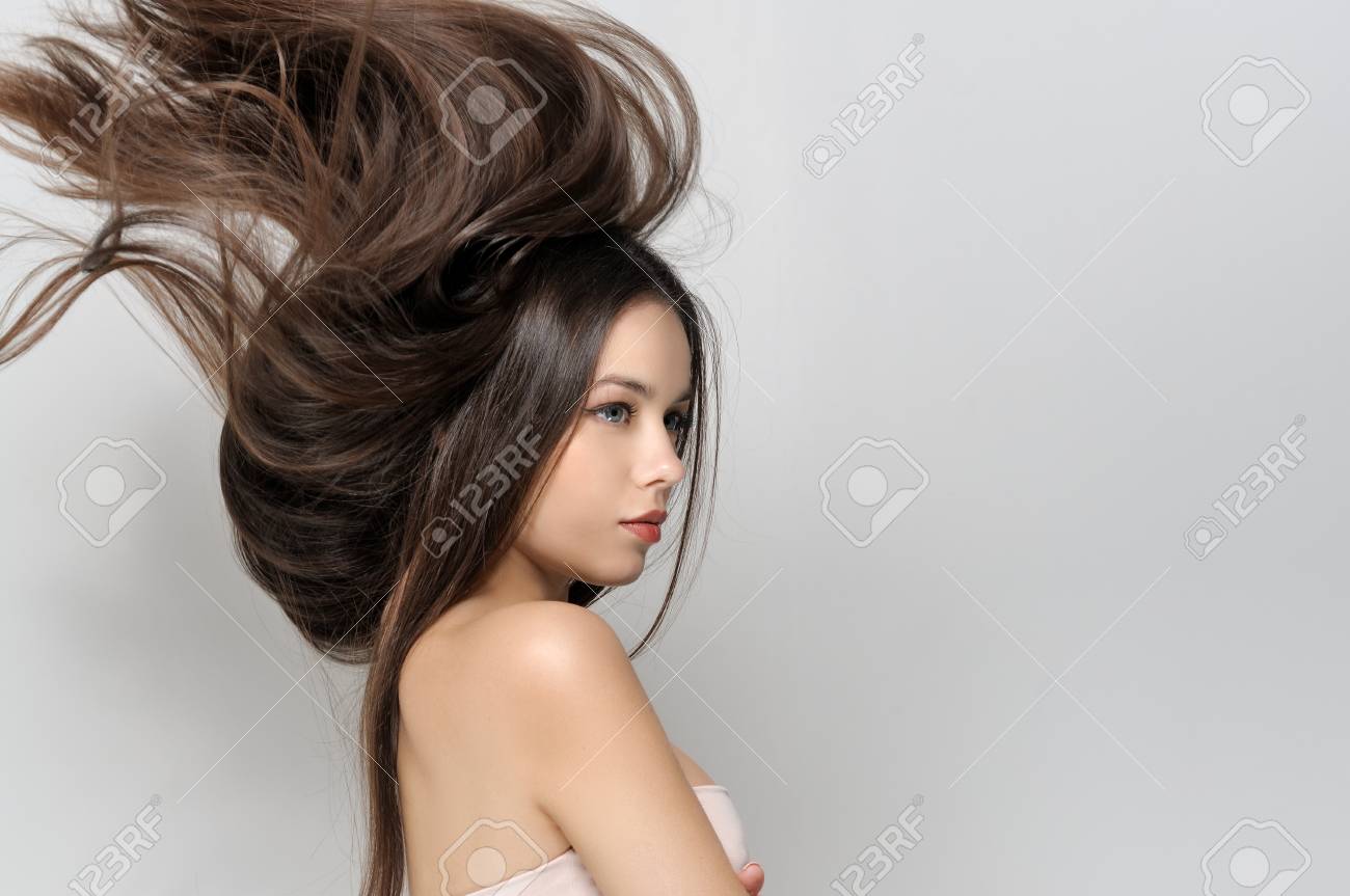 髪風から飛ぶ 裸の肩を持つ美しい女性 きれいな手入れの行き届いた肌 長いストレートの髪 明るいグレーの背景からクローズ アップ肖像画 の写真素材 画像素材 Image