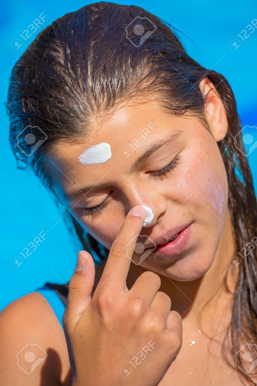 かわいい若い女の子の顔に塗る日焼け止めを保護します の写真素材 画像素材 Image