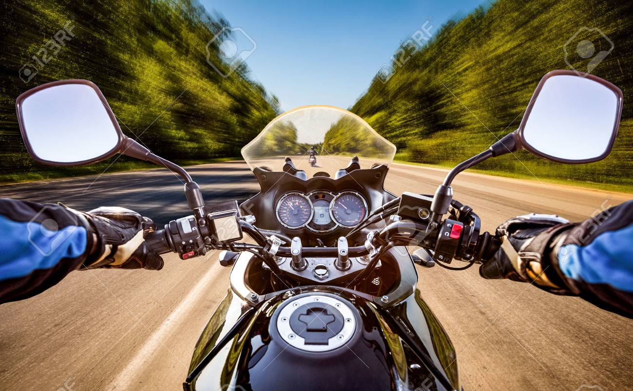 Biker driving a motorcycle rides along the asphalt road. First-person view. - 54766213 Biker driving a motorcycle rides along the asphalt road. First-person view. - 54766213