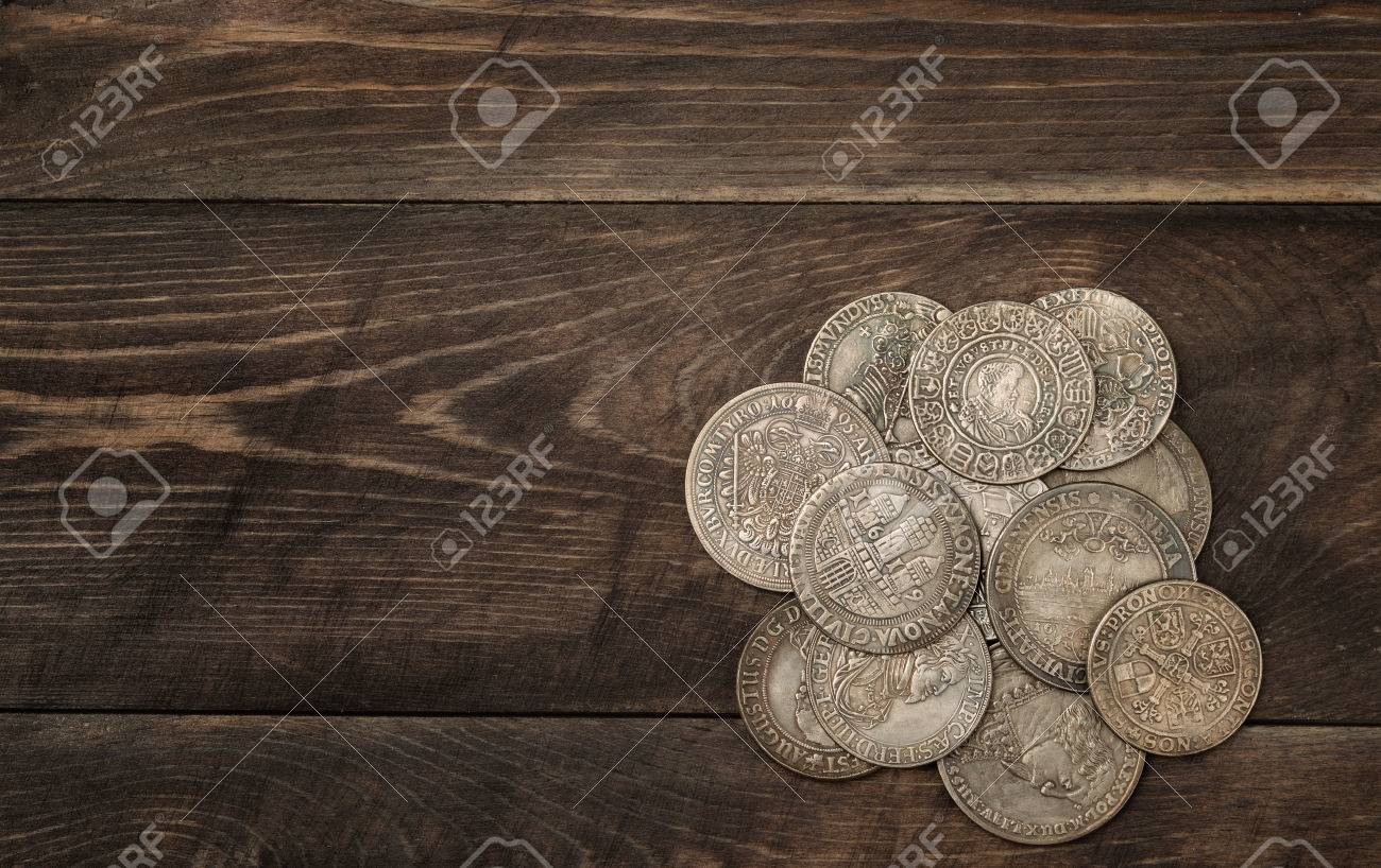 Ancient silver coins on dark wooden background - 55758298 Ancient silver coins on dark wooden background - 55758298
