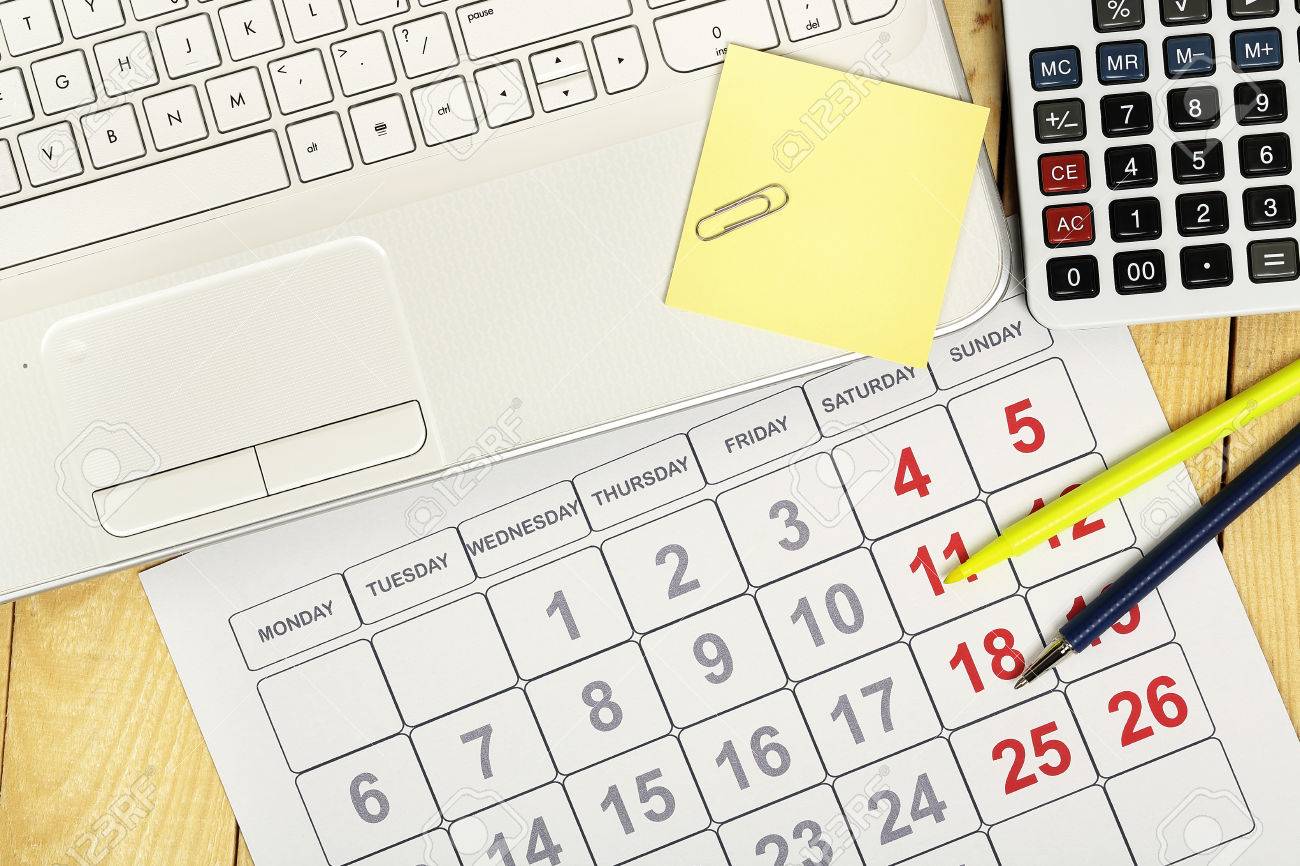 laptop with calendar and calculator on office desk office calander