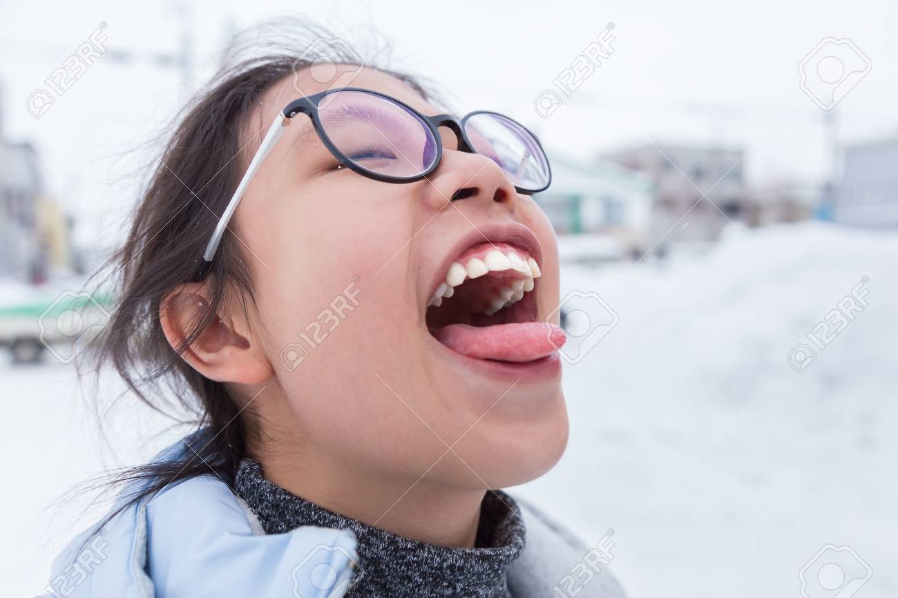 japan girl tongue Asian Teenager Sticking Out Her Tongue Trying To Catch Falling Snow On A Cold Winter Day In Japan, Good For Fun And Staying Young Theme Stock Photo, Picture and Royalty Free Image.