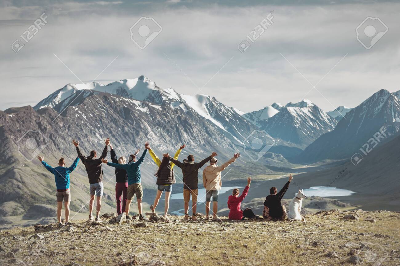 Big group of happy young hikers are standing with raised arms in mountains - 144664993 Big group of happy young hikers are standing with raised arms in mountains - 144664993