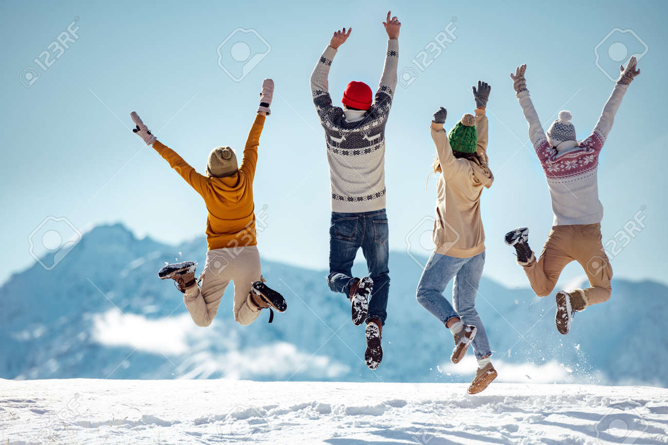 Friends celebrates beginning of winter in mountains, jumps and having fun - 158053518 Friends celebrates beginning of winter in mountains, jumps and having fun - 158053518
