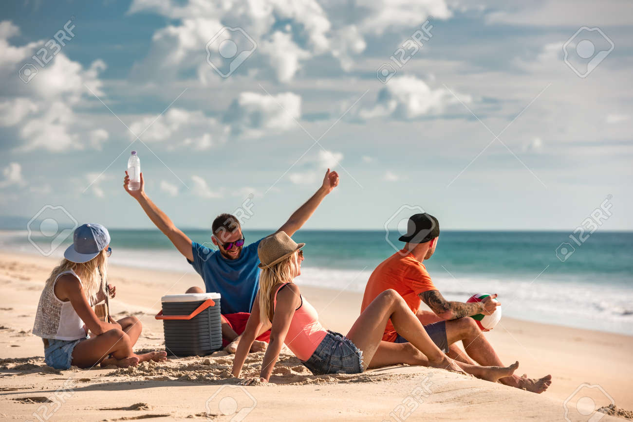 Group of friends are having fun and relaxing at sea beach picnic - 165561397 Group of friends are having fun and relaxing at sea beach picnic - 165561397