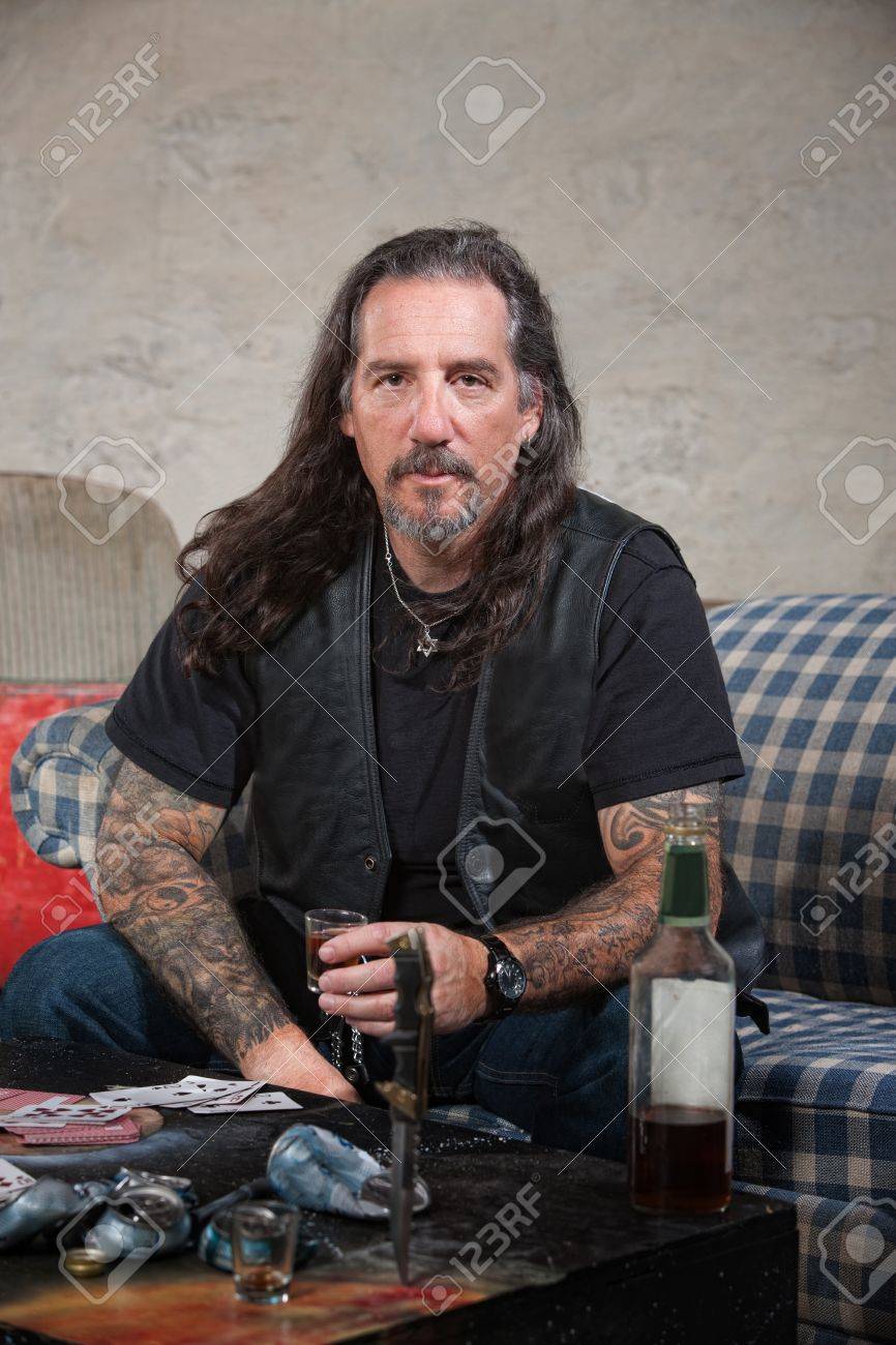 深刻なバイカー ギャングのメンバーと酒とテーブル上の短剣 の写真素材 画像素材 Image