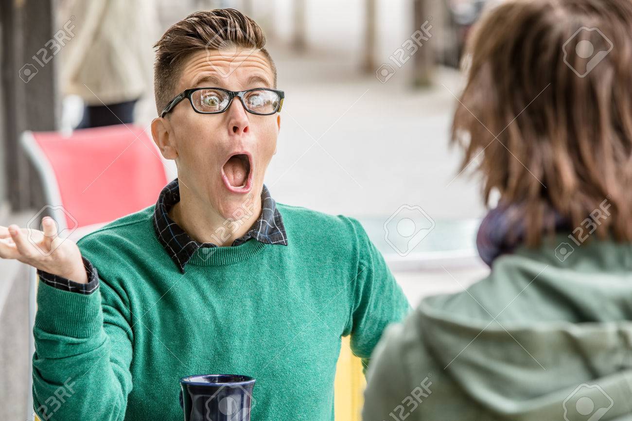 Yelling woman in green sweater talking with unidentifiable friend at outdoor restaurant - 66029270 Yelling woman in green sweater talking with unidentifiable friend at outdoor restaurant - 66029270
