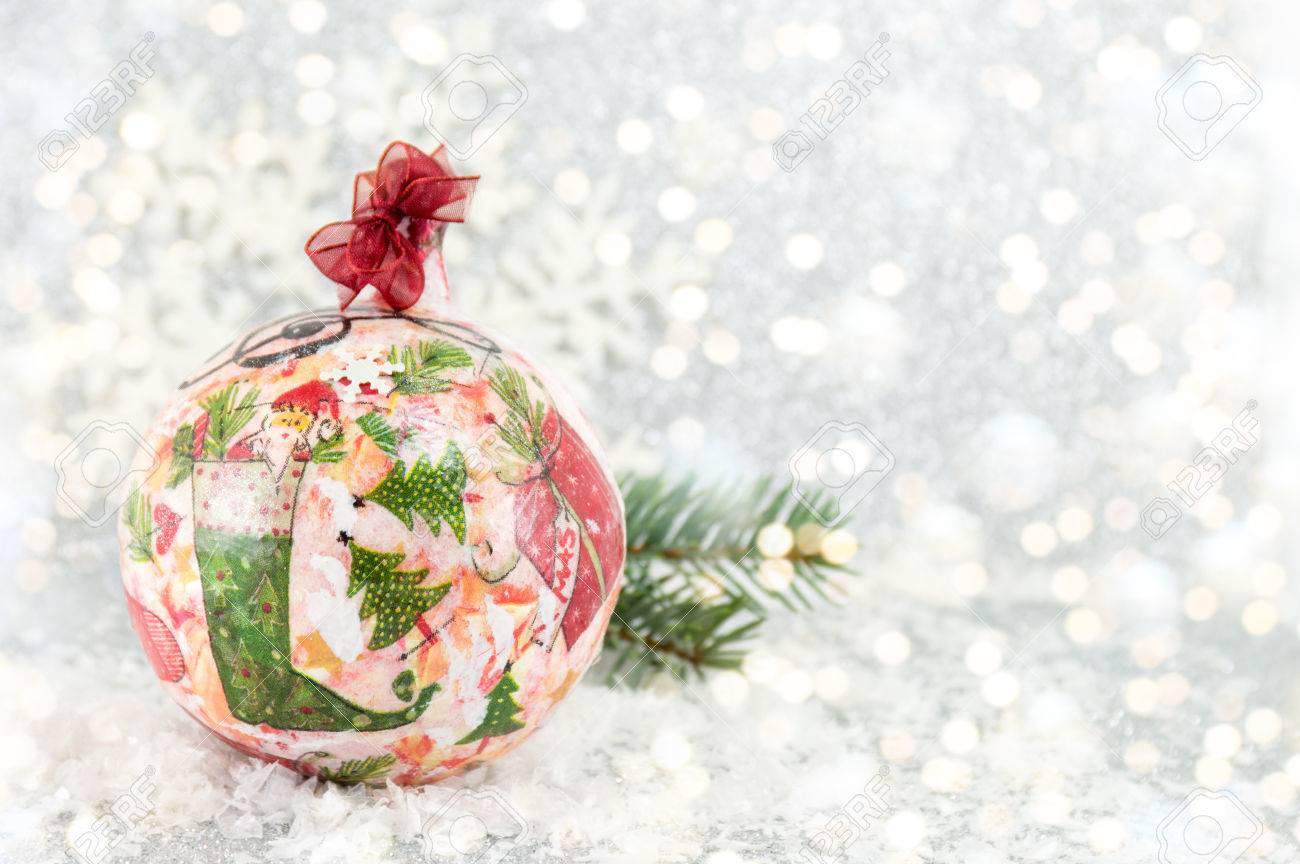 decoupage Christmas ball on a snowy surface with a big snowflake