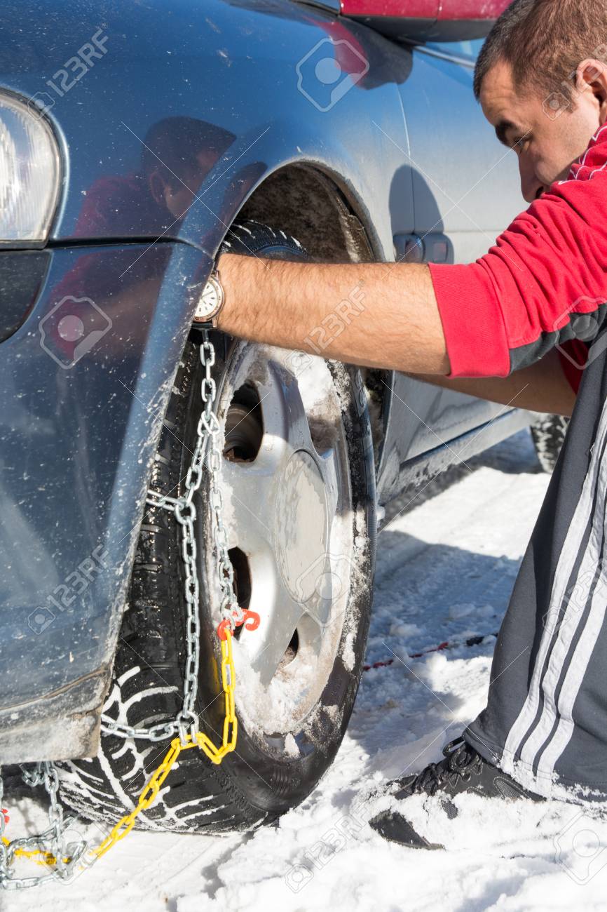 男が車の車輪にスノー チェーンを装着 の写真素材 画像素材 Image