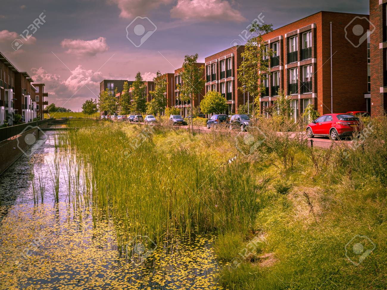 91311815-modern-ecological-street-with-middle-class-family-apartments-and-natural-eco-friendly-river-bank-in.jpg