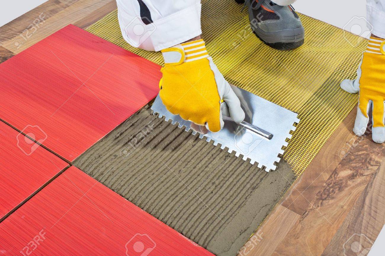 Worker Apply Ceramic Tiles On Wooden Floor Mesh Trowel Stock Photo