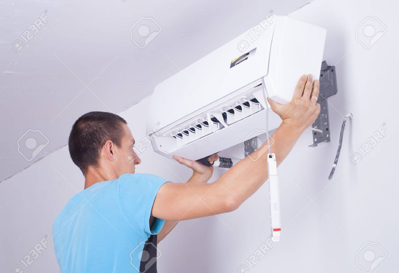 man installs indoor unit of the air conditioner - 42233835 man installs indoor unit of the air conditioner - 42233835