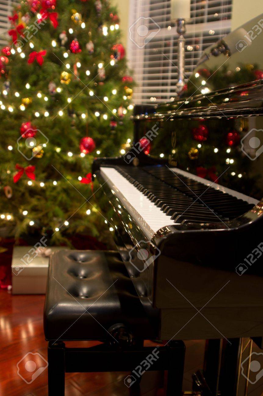 baby grand piano with christmas tree presents in background baby grand piano with christmas tree presents in background