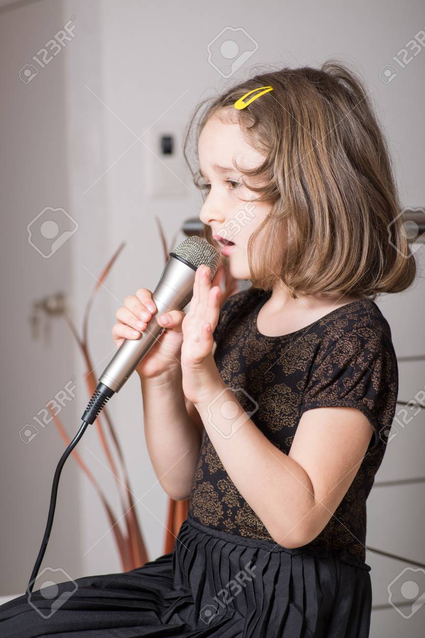 小さなかわいい女の子カラオケ マイクを自宅で の写真素材 画像素材 Image