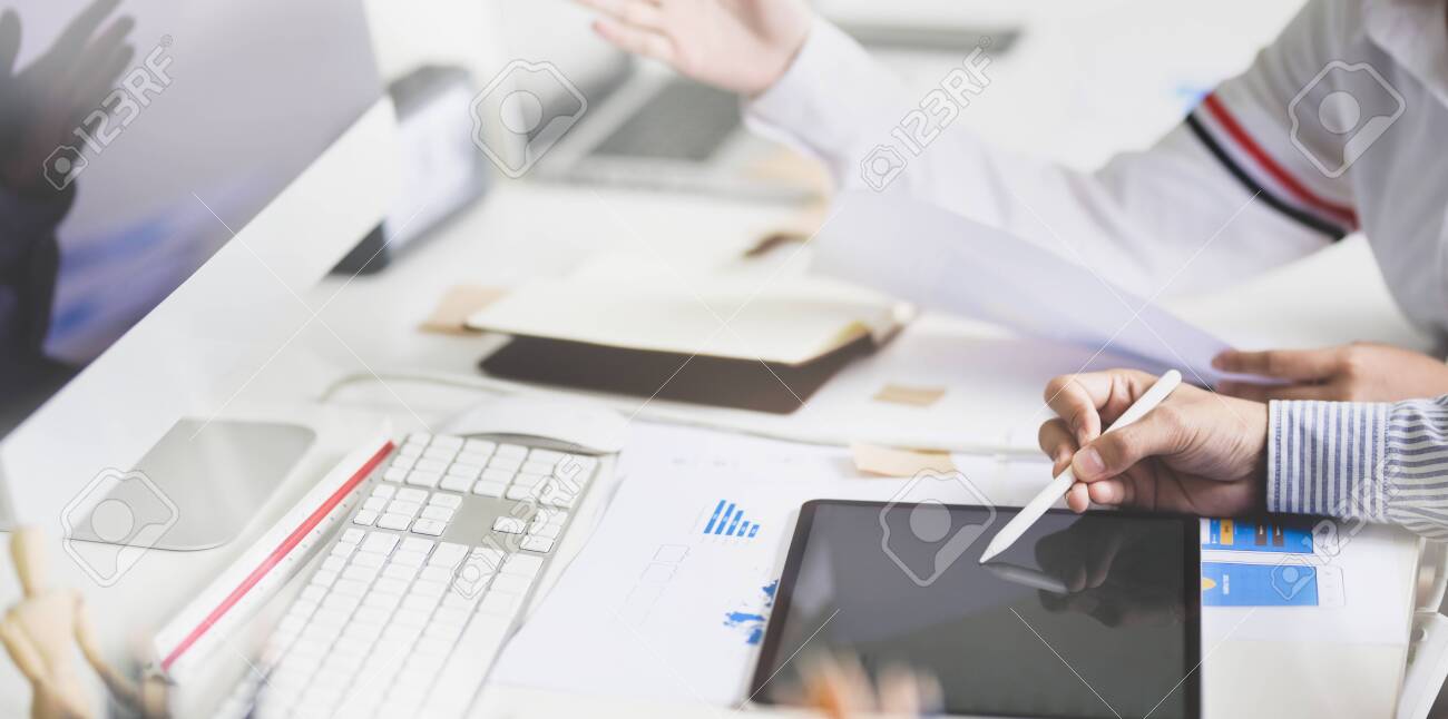 Young development team consulting their project while using tablet in modern office - 128373672 Young development team consulting their project while using tablet in modern office - 128373672