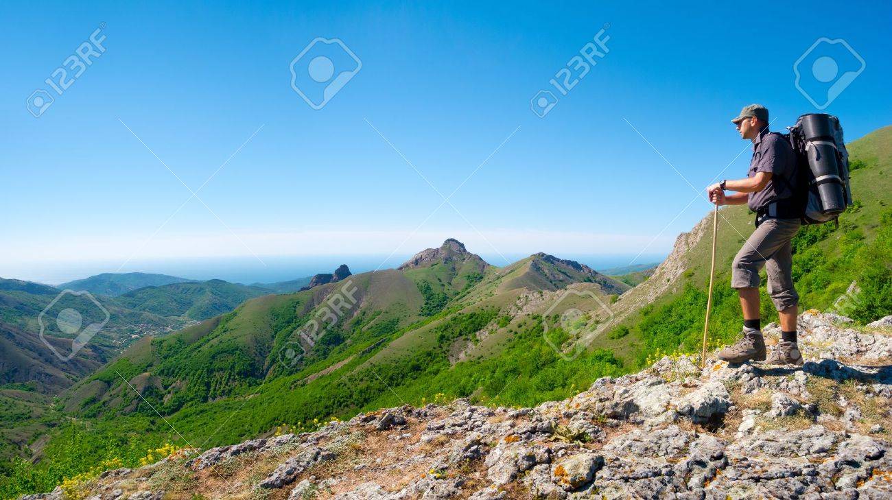 Hiker standing on a stone ridge and enjoys landscape - 19980112 Hiker standing on a stone ridge and enjoys landscape - 19980112