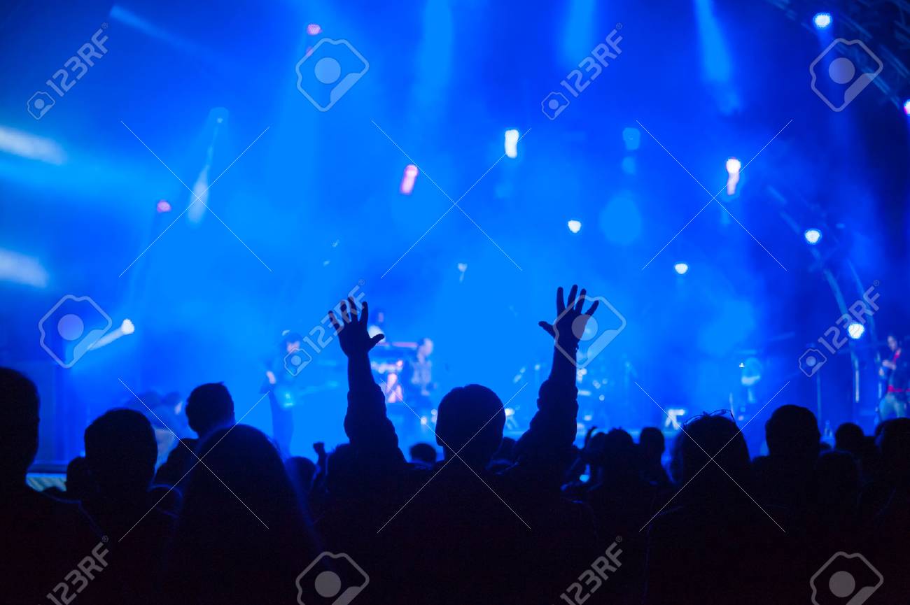 Fans cheering at an open-air live concert. - 41967921 Fans cheering at an open-air live concert. - 41967921