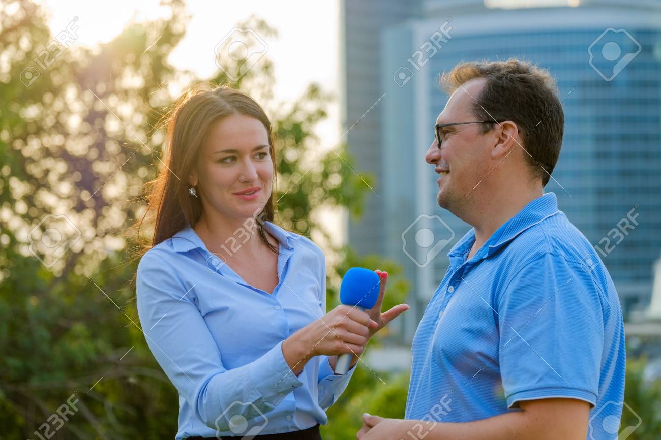 Young girl TV reporter interviews a man - 87279448 Young girl TV reporter interviews a man - 87279448
