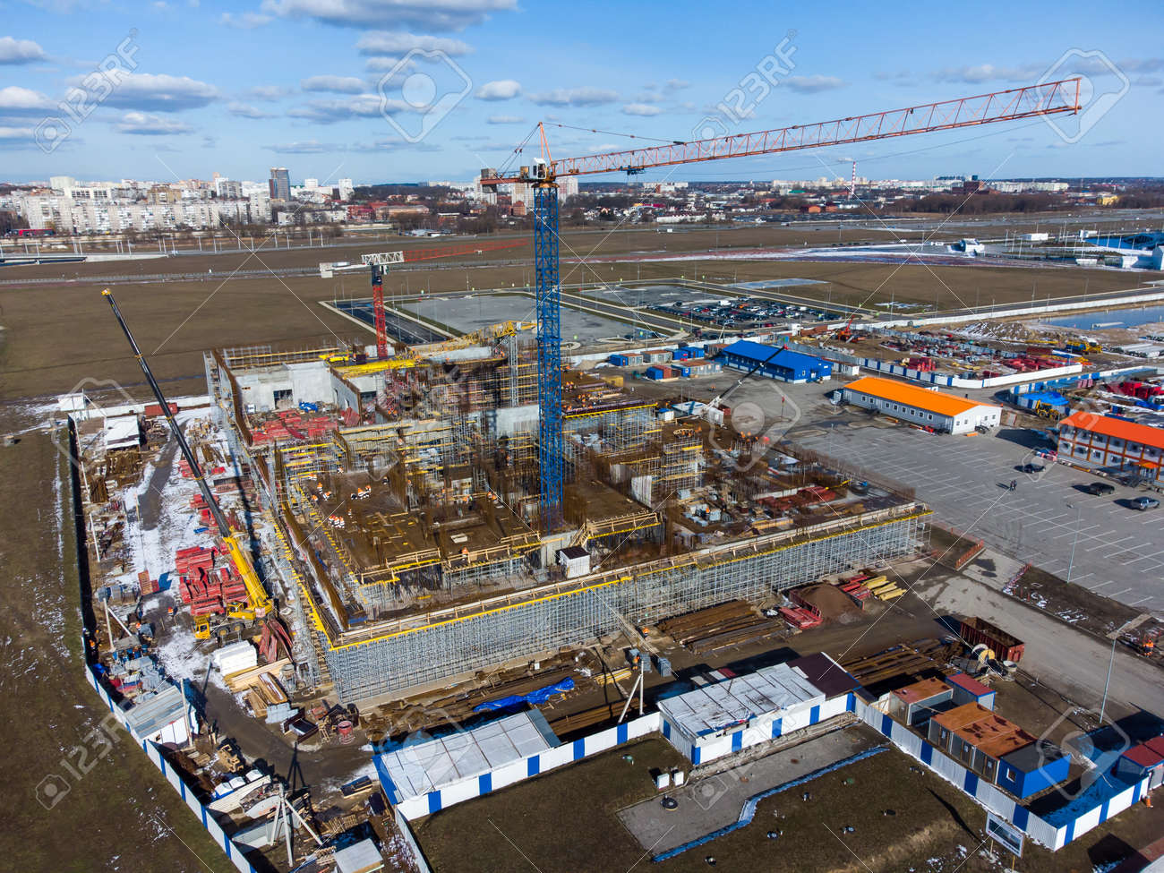 Drone view of tall crane located in middle of construction site near unfinished building in city outskirts - 166232718 Drone view of tall crane located in middle of construction site near unfinished building in city outskirts - 166232718