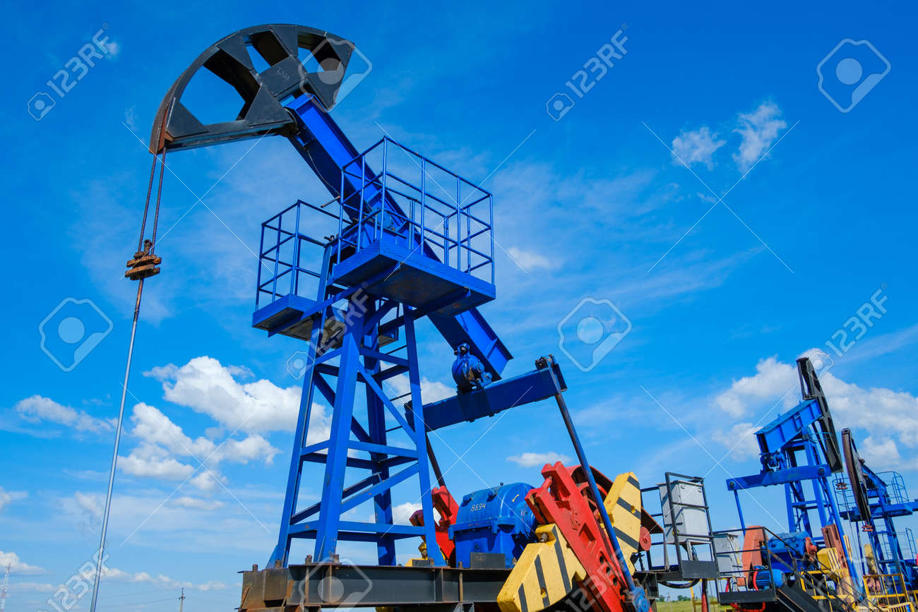From below industrial machinery pumping oil from wells against cloudy sky on sunny day in countryside - 166158214 From below industrial machinery pumping oil from wells against cloudy sky on sunny day in countryside - 166158214