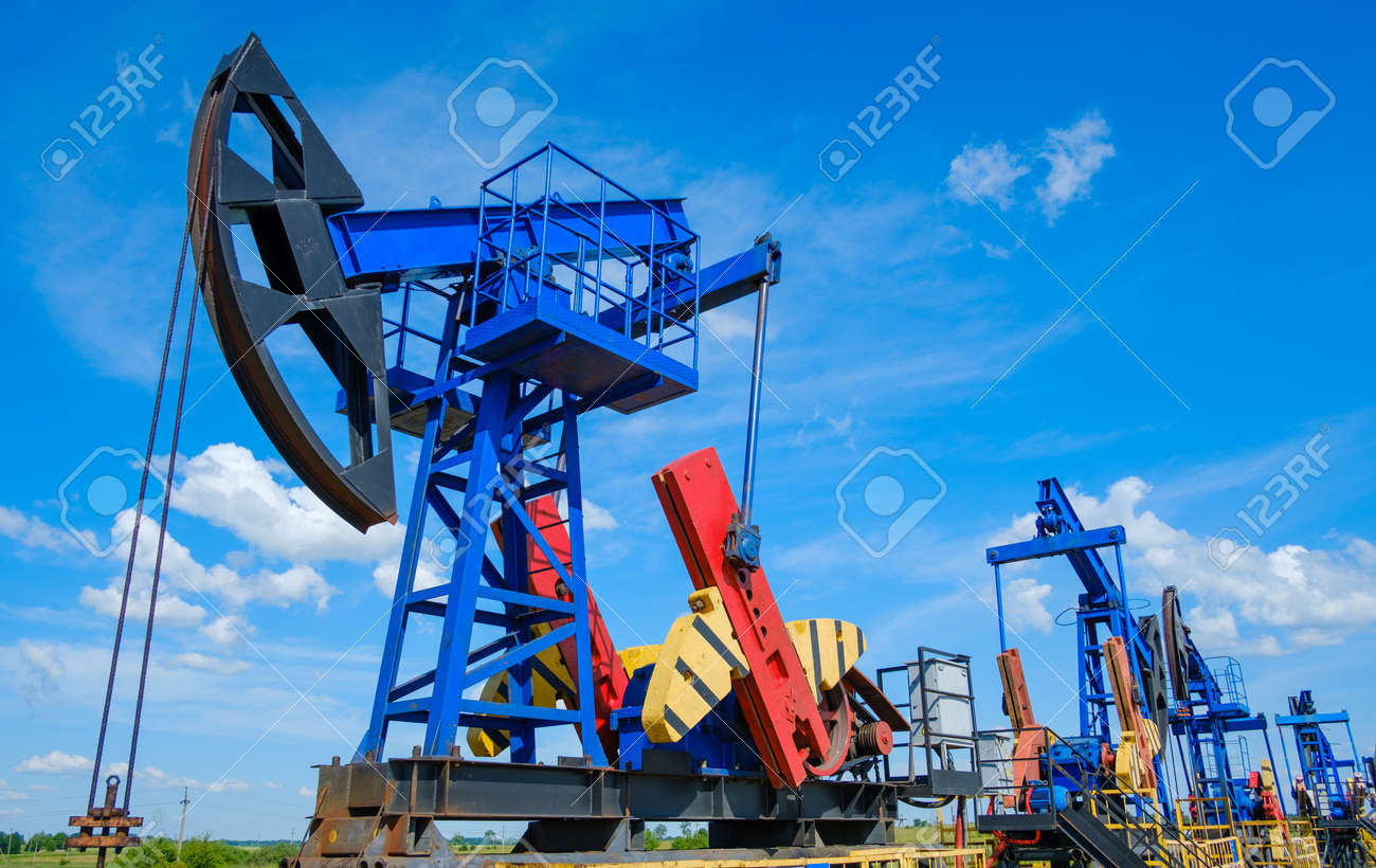 From below industrial machinery pumping oil from wells against cloudy sky on sunny day in countryside - 166232728 From below industrial machinery pumping oil from wells against cloudy sky on sunny day in countryside - 166232728