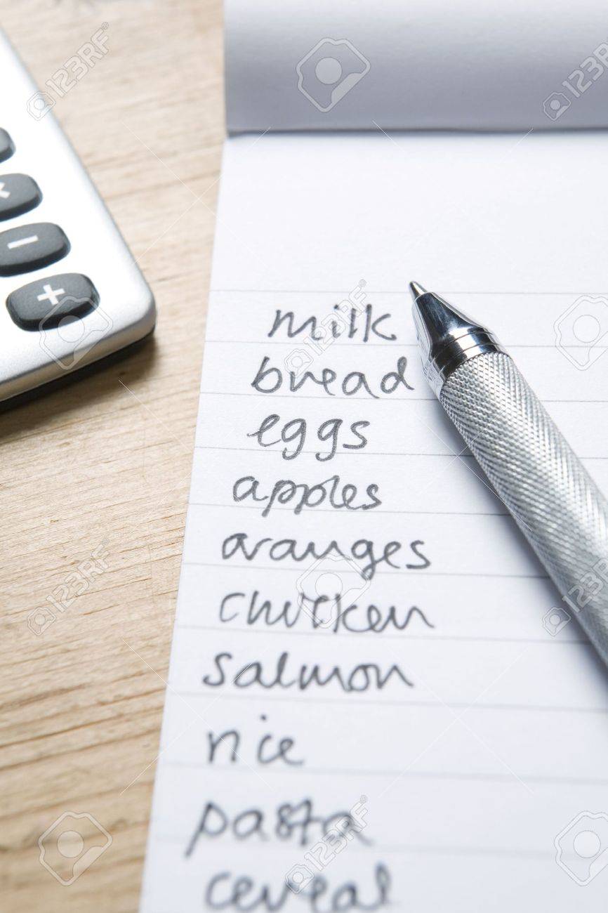 handwritten shopping list with pen and calculatot handwritten grocery list