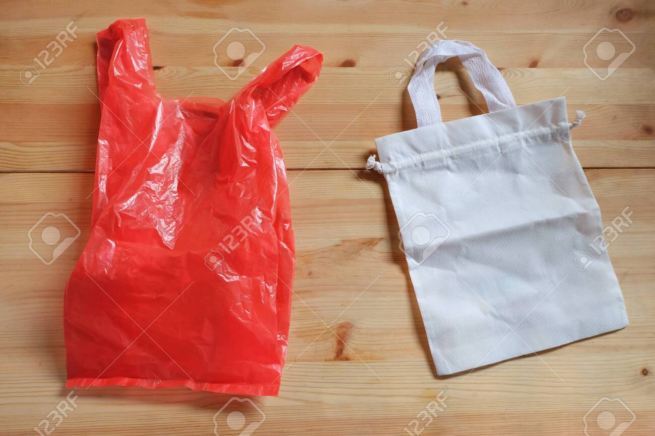 Plastic Bag And White Canvas Cloth Bag On Wooden Floor Replace
