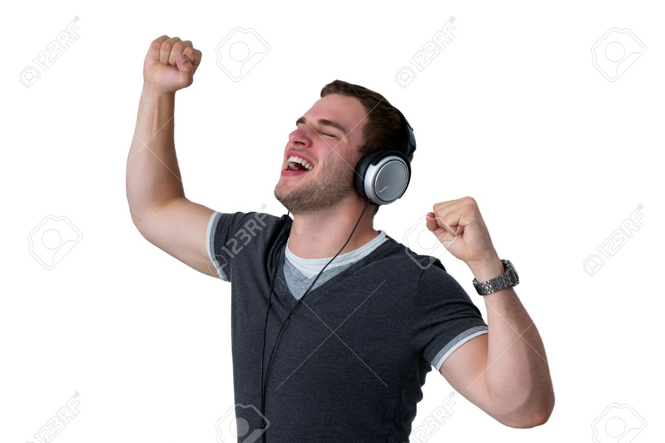 young man listening to music and dancing with arms in air stock